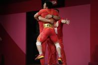 Chen Lijun of China celebrates after winning the gold medal and setting an Olympic record in the men's 67kg weightlifting event, at the 2020 Summer Olympics, Sunday, July 25, 2021, in Tokyo, Japan. (AP Photo/Luca Bruno)