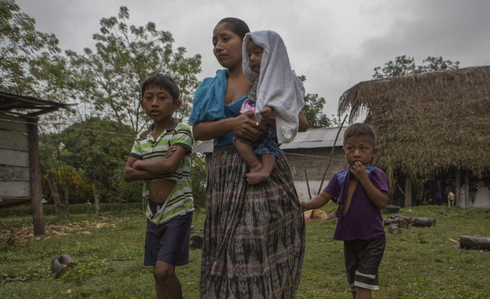 Claudia Maquin, 27, walks with her three children, Abdel Johnatan Domingo Caal Maquin, 9, left, Angela Surely Mariela Caal Maquin, 6 months, middle, and Elvis Radamel Aquiles Caal Maquin, 5, right, as they leave Domingo Caal Chub's house, Claudia's father in law, in Raxruha, Guatemala, Saturday, Dec. 15, 2018. Claudia Maquin's daughter, 7-year-old Jakelin Amei Rosmery Caal, died in a Texas hospital, two days after being taken into custody by border patrol agents in a remote stretch of New Mexico desert. (AP Photo/Oliver de Ros)