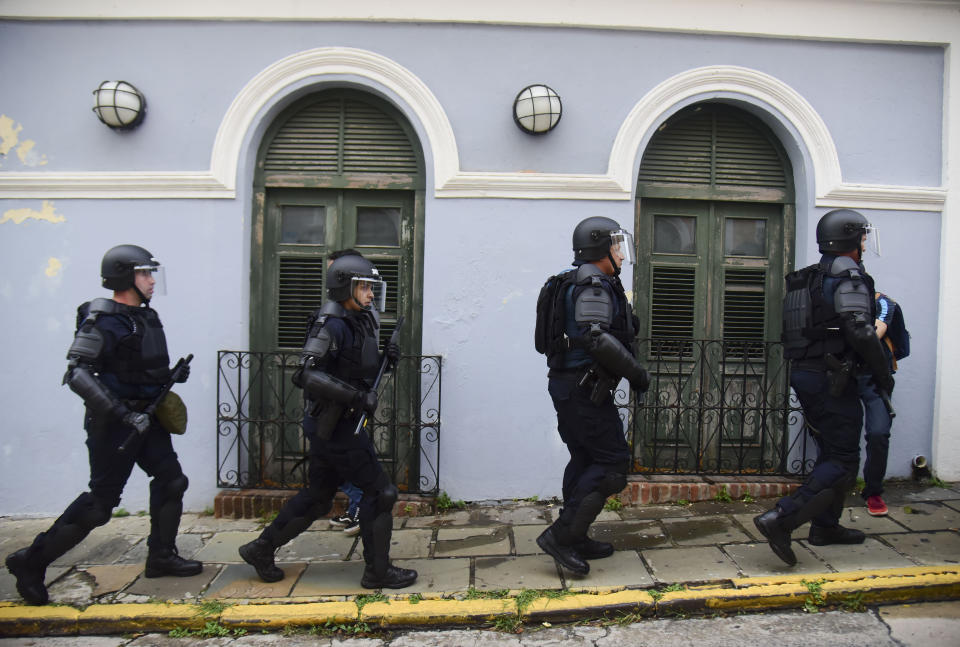 Police walk toward protesters near La Fortaleza governor's residence in San Juan, Puerto Rico, Sunday, July 14, 2019. Protesters are demanding Gov. Ricardo Rosselló step down for his involvement in a private chat in which he used profanities to describe an ex-New York City councilwoman and a federal control board overseeing the island's finance. (AP Photo/Carlos Giusti)