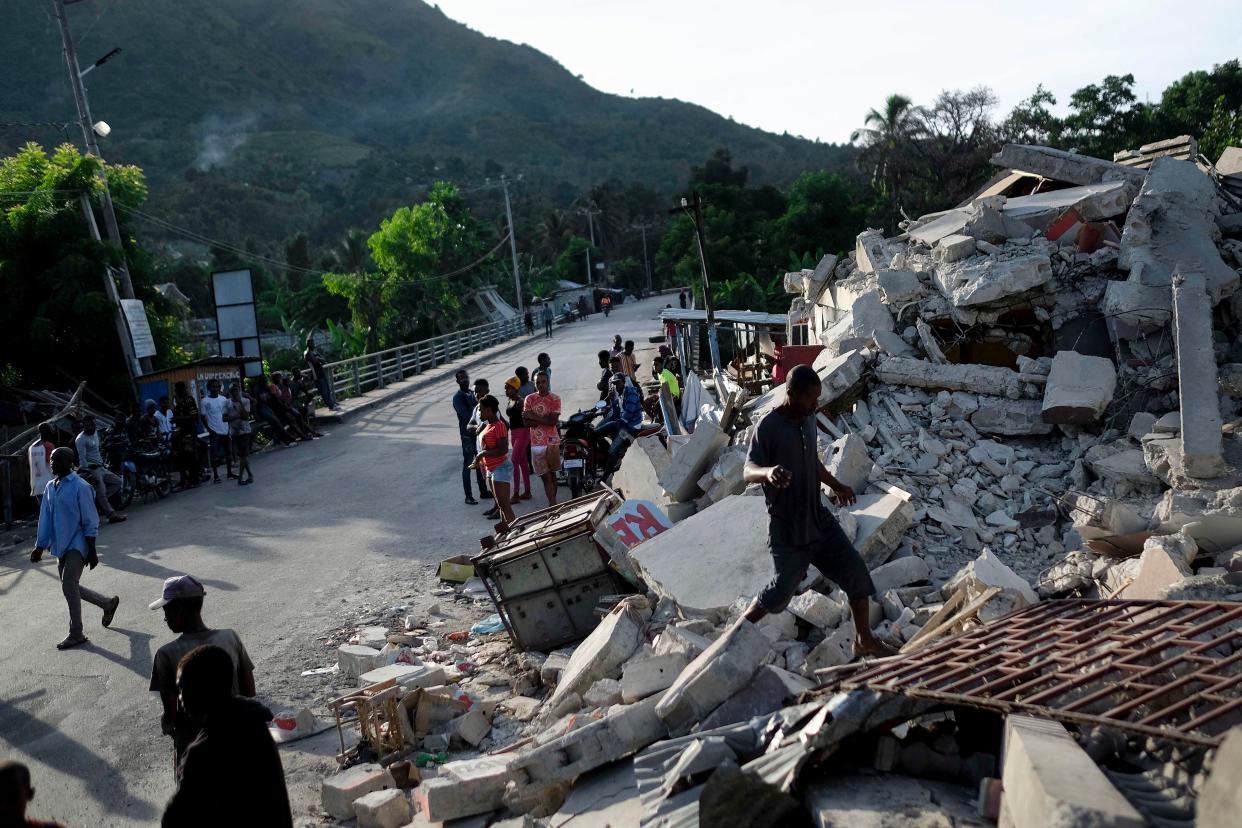 A man walks on a collapsed building in Saint-Louis-du-Sud, Haiti on Monday, Aug. 16, 2021, two days after a 7.2-magnitude earthquake struck the southwestern part of the hemisphere's poorest nation on Aug. 14.