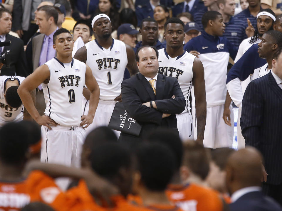 Pittsburgh's James Robinson (0), Jamel Artis (1), Michael Young, right center, watch along with director of men's basketball operations Brian Regan, center, as the officials check the replay on the time of the last shot of an NCAA college basketball game against Syracuse on Wednesday, Feb. 12, 2014, in Pittsburgh. Syracuse won 58-56 on the 3-point shot with less than a second left in the game. (AP Photo/Keith Srakocic)