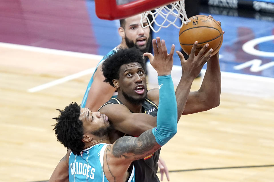 Chicago Bulls' Thaddeus Young, center, scores against Charlotte Hornets' Miles Bridges, left, during the first half of an NBA basketball game Thursday, April 22, 2021, in Chicago. (AP Photo/Charles Rex Arbogast)