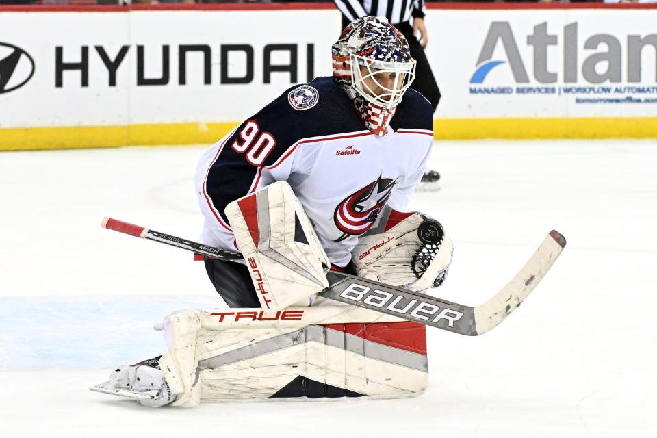 Columbus Blue Jackets goaltender Elvis Merzlikins (90) gloves the puck during the second period of an NHL hockey game against the New Jersey Devils, Friday, Nov. 24, 2023, in Newark, N.J. (AP Photo/Bill Kostroun)