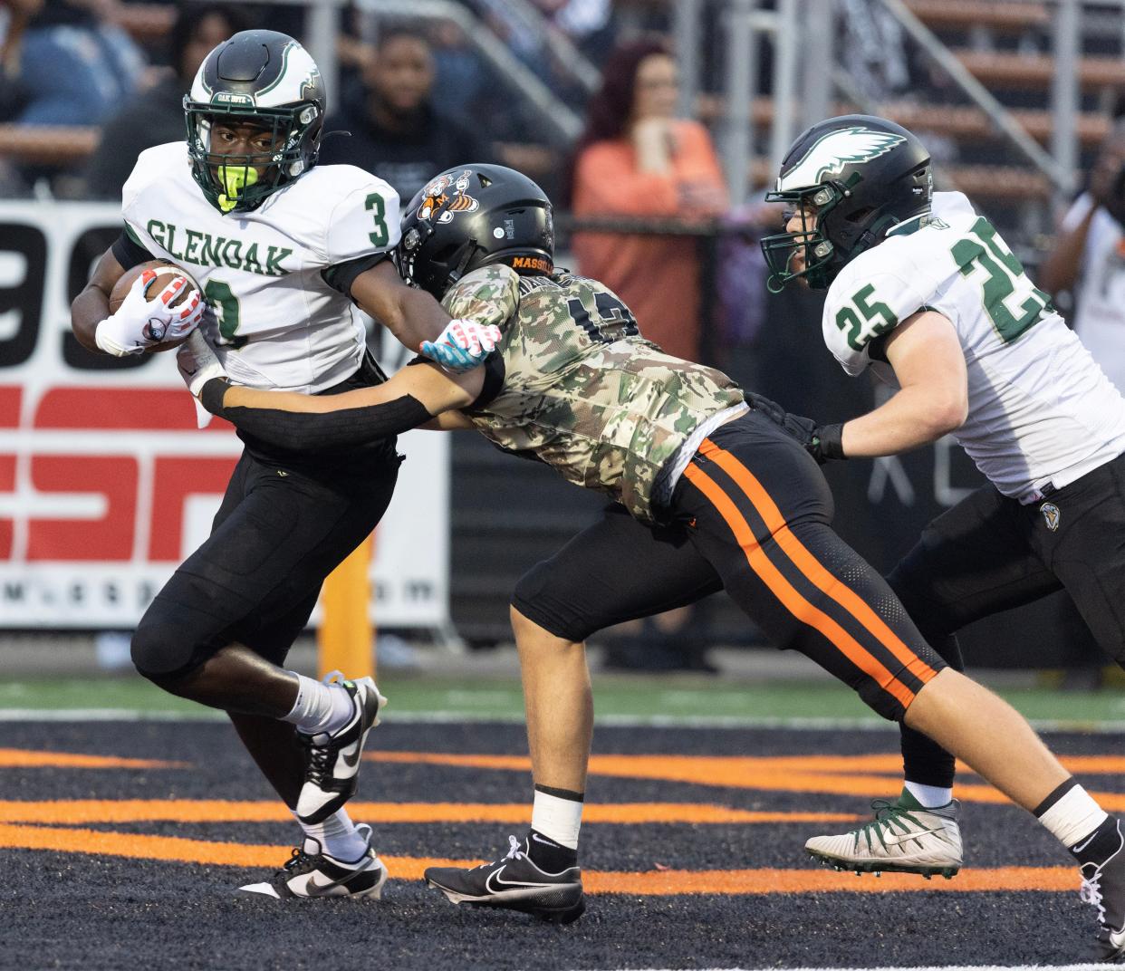 GlenOak's Jamar Johnson fights for yardage as Massillon's Vito McConnell comes in for the stop in Week 2 of 2023. GlenOak's Matt Rekstis is also in on the play.