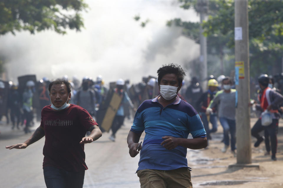 Anti-coup protesters run away when police security forces try to disperse them with tear gas in Mandalay, Myanmar, Saturday, March 13, 2021. Myanmar's military seized power Feb. 1, hours before the seating of a new parliament following election results that were seen as a rebuff to the country's generals. (AP Photo)