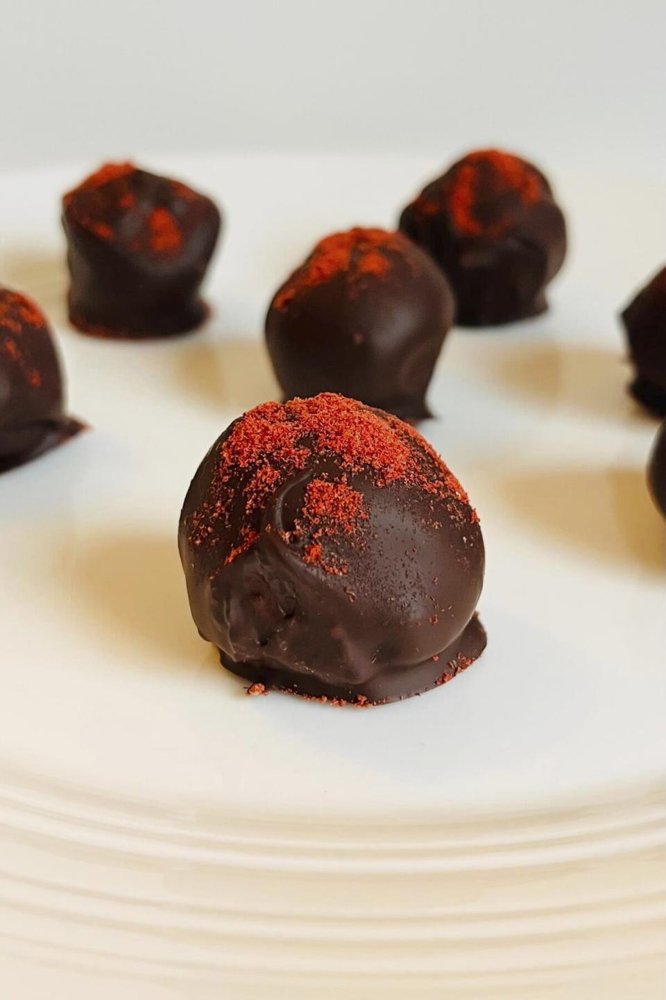This image shows a plate of chocolate truffles. Rather than spending on store-bought chocolates for Valentine’s Day, make them together as a fun way to spend the evening with your Valentine. (Jennifer Bell via AP)
