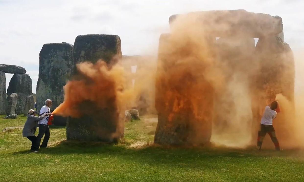 <span>An image taken from a video released by the Just Stop Oil climate campaign group shows activists spraying orange powder paint at Stonehenge in Wiltshire.</span><span>Photograph: Just Stop Oil/AFP/Getty Images</span>
