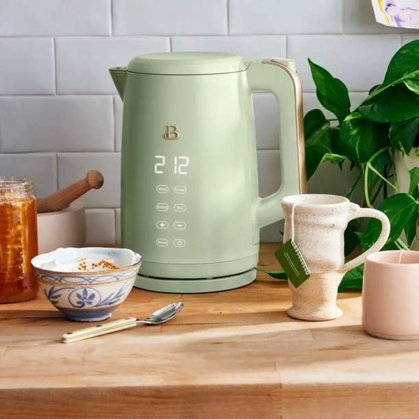 Light green kettle on a butcher block countertop