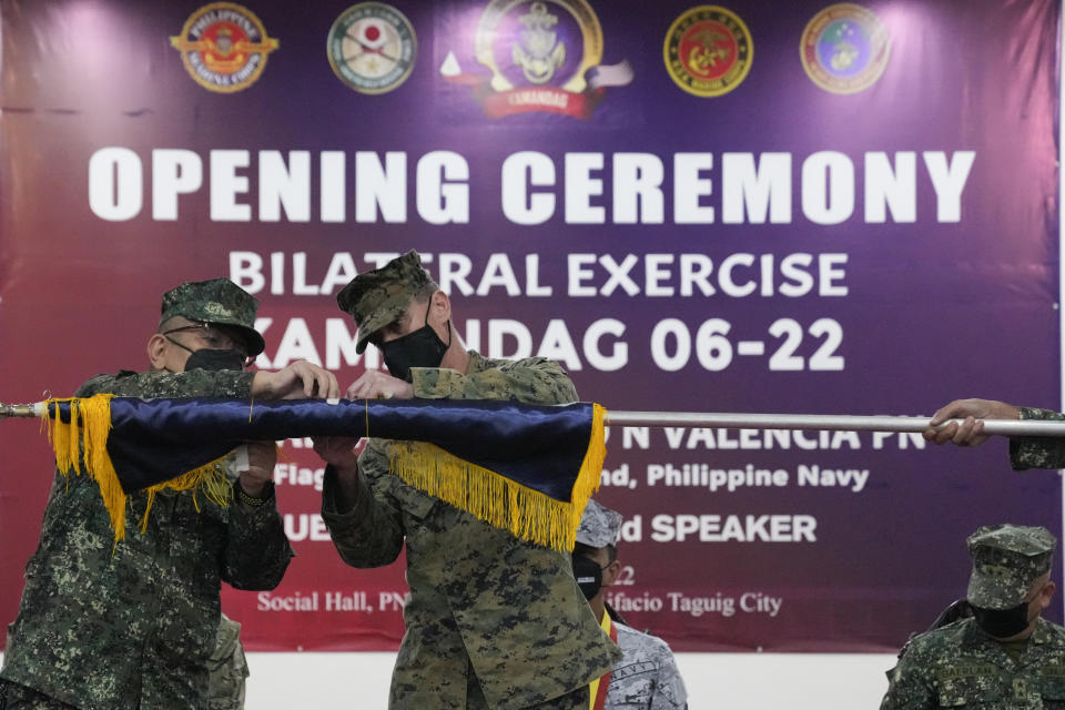 Philippine Navy Marine Brig. Gen. Raul Jesus Caldez, left, and U.S. Marine Corp Col. Deric Ayers unfurl the exercise flag during opening ceremonies of an annual joint military exercise called Kamandag the Tagalog acronym for "Cooperation of the Warriors of the Sea" at Fort Bonifacio, Taguig city, Philippines on Monday Oct. 3, 2022. More than 2,500 U.S. and Philippine marines launched combat exercises Monday to be able to jointly respond to any sudden crisis in a region long on tenterhooks over the South China Sea territorial disputes and China's increasingly hostile actions against Taiwan. (AP Photo/Aaron Favila)