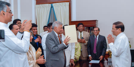 Ranil Wickremesinghe, ousted prime minister in October, takes his oath for the same post before Sri Lanka's President Maithripala Sirisena during his swearing-in ceremony in Colombo, Sri Lanka December 16, 2018. President's Media Division/Handout via REUTERS