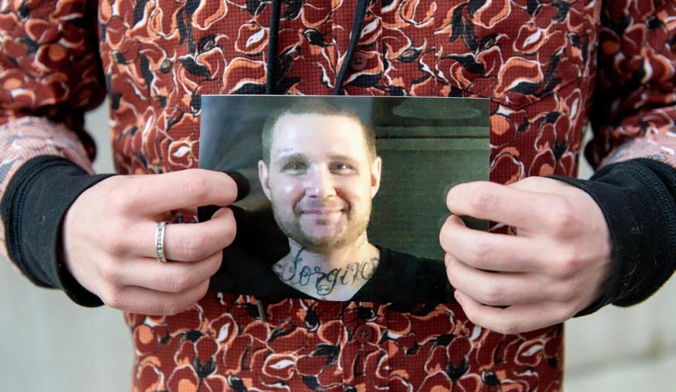 Rielly Everson holds a photo of his dad Ryan outside of the Clay County Detention Center on Wednesday, Feb. 22, 2023, in Liberty, Mo.