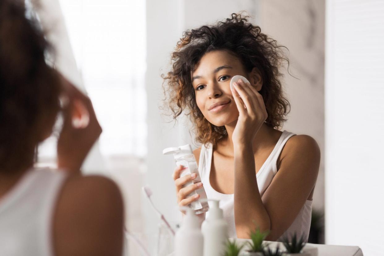 woman using cotton pad on face