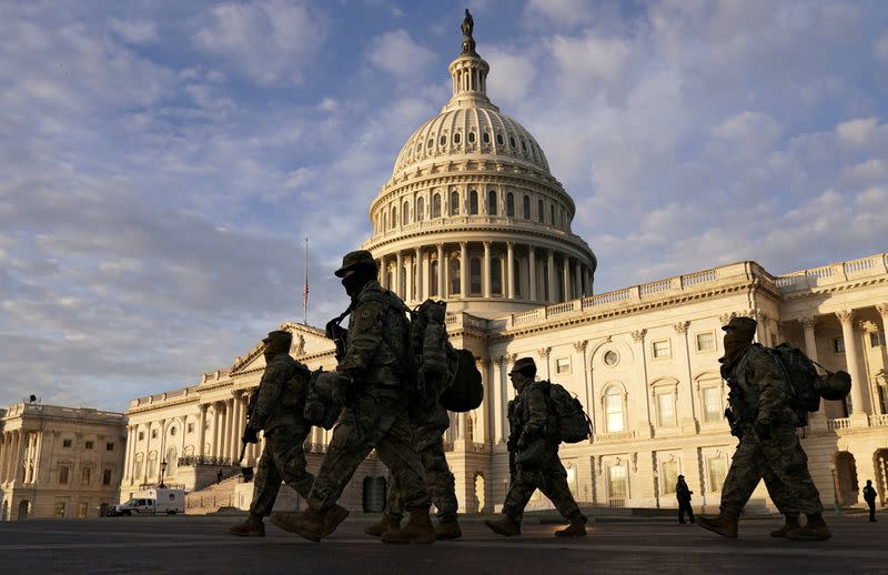 National Guard members walk in front of the U.S. Capitol after the House voted to impeach U.S. President Donald Trump in Washington