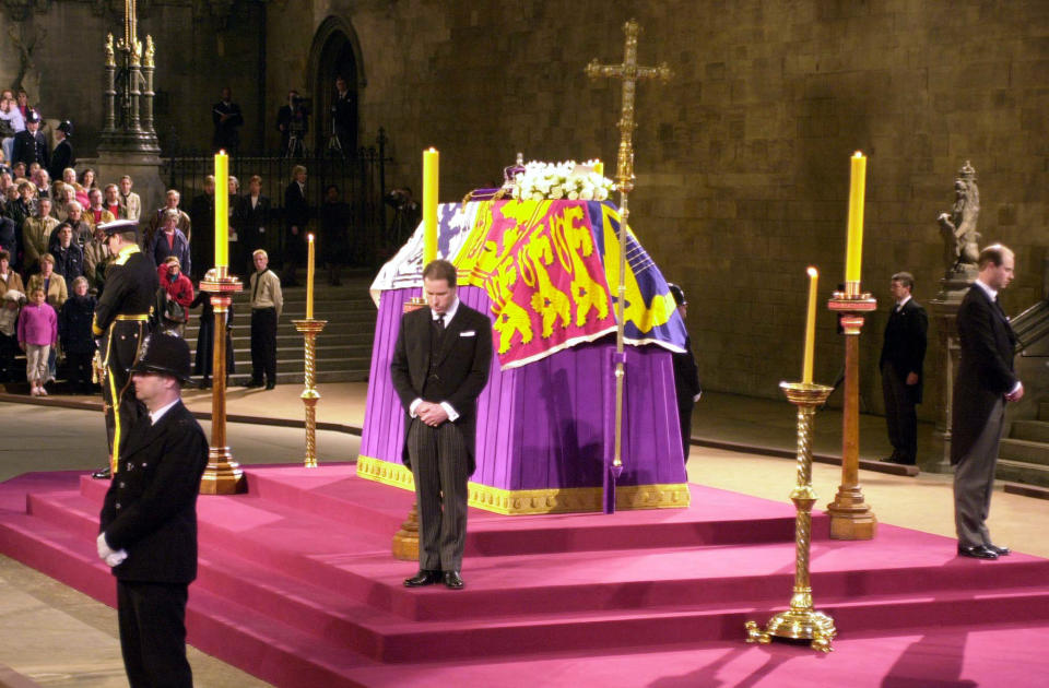 FILE - The flag-drapped coffin of Queen Elizabeth the Queen Mother Lies-in-State, as it is guarded at the four corners of the catafalque by her four grandsons: the Duke of York, left, the Earl of Wessex, right, Viscoount Linley, center, and the Prince of Wales, hidden - far side, in Westminster Hall London on the eve of her funeral, Monday, April 8, 2002. When Queen Elizabeth II’s grandfather, King George V, died in 1936, life in Britain is unrecognizable to people today. But despite almost a century of change, the images from the queen’s lying in state this week are almost exact copies of those from George V’s time. (John Stillwell, Pool photo via AP, File)