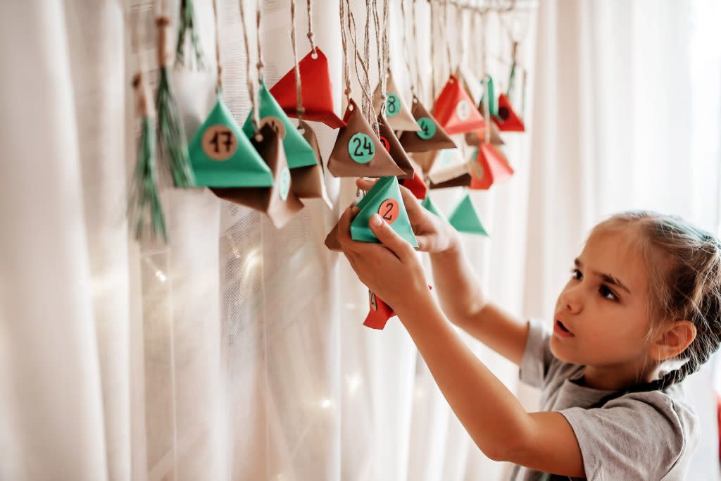 A little girl uses a homemade advent calendar. 