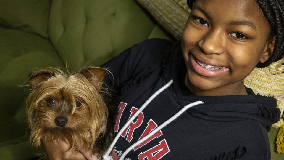 Semaj Witherspoon, 13, poses with her Yorkshire Terrier, Avery, at home in Landover, Maryland, on Dec. 22, 2022. (Bill O'Leary/The Washington Post via AP)
