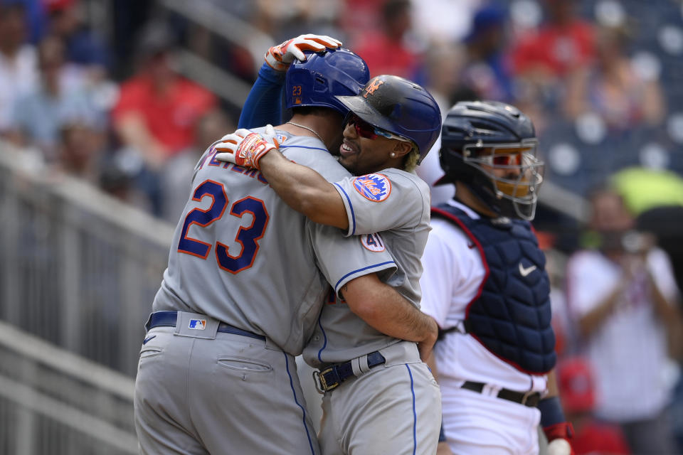 New York Mets' Francisco Lindor, center, celebrates his two-run home run with David Peterson (23) during the fifth inning of the first baseball game of a doubleheader, Saturday, June 19, 2021, in Washington. At right is Washington Nationals catcher Alex Avila. This is a makeup of a postponed game from April 1. (AP Photo/Nick Wass)