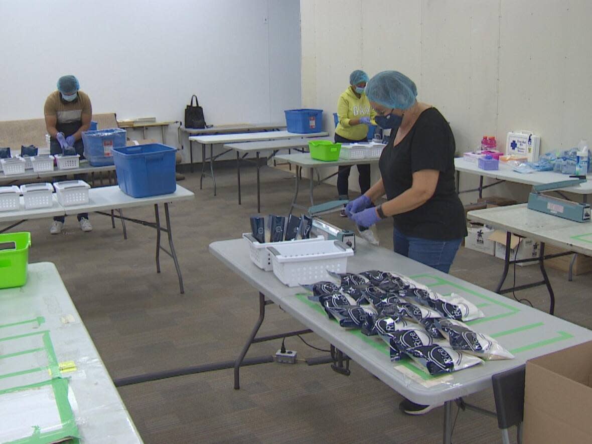 Volunteers for disaster relief organization GlobalMedic are seen packaging food in Toronto's Cloverdale Mall. The packages will go to families in Atlantic Canada impacted by post-tropical storm Fiona. (CBC - image credit)