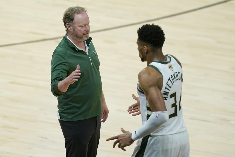 Milwaukee Bucks head coach Mike Budenholzer, left, greets forward Giannis Antetokounmpo during the second half of Game 2 of basketball's NBA Finals against the Phoenix Suns, Thursday, July 8, 2021, in Phoenix. (AP Photo/Ross D. Franklin)