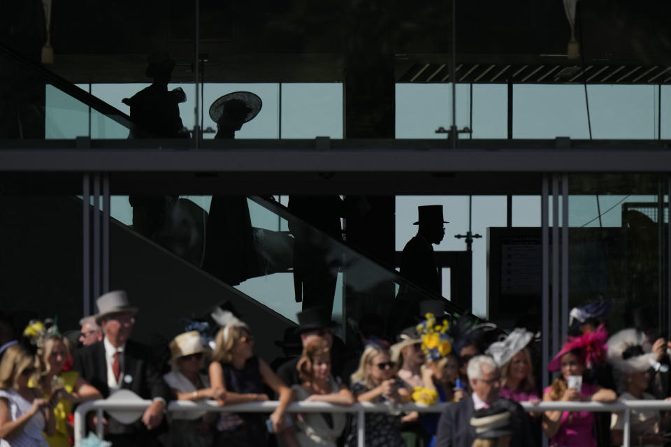 Racegoers watch the parade ring as escalators take patrons to the Royal Enclosure on the third day of the Royal Ascot horserace meeting, at Ascot Racecourse, in Ascot, England, Thursday, June 16, 2022. The third day is traditionally known as Ladies Day. (AP Photo/Alastair Grant)