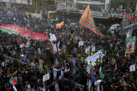 Supporters of Pakistan's former Prime Minister Imran Khan's 'Pakistan Tehreek-e-Insaf' party attend a rally, in Rawalpindi, Pakistan, Saturday, Nov. 26, 2022. Khan said Saturday his party was quitting the country's regional and national assemblies, as he made his first public appearance since being wounded in a gun attack earlier this month. (AP Photo/Anjum Naveed)