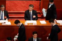 Attendants serve tea around Chinese President Xi Jinping at the opening session of NPC in Beijing