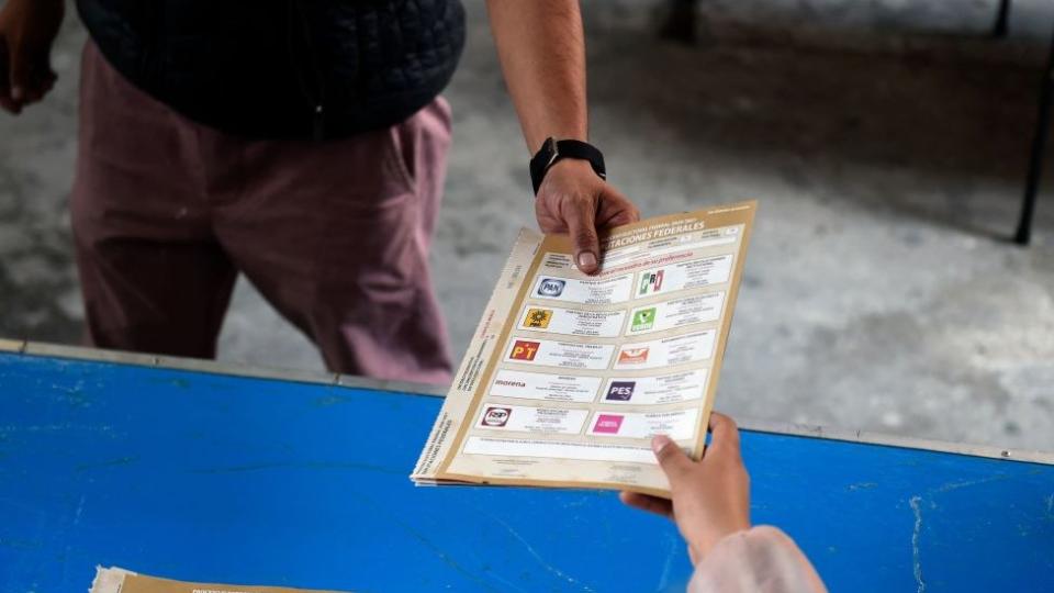 Entrega de boleta con diferentes partidos políticos.