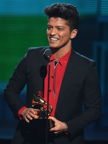 <p>Kevin Winter/WireImage</p> Bruno Mars speaks onstage during the 56th GRAMMY Awards on January 26, 2014 in Los Angeles, California.