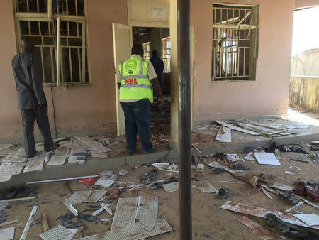 A National Emergency Management Agency (NEMA) staff inspects the damage at the site of a suicide bomber attack in Mubi in Adamawa state, in northeastern Nigeria November 21, 2017. NEMA/Handout via REUTERS