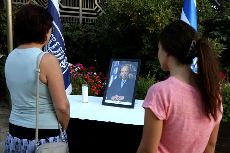 Israeli women look at a framed portrait of former Israeli president and Nobel Peace Prize winner Shimon Peres displayed after his death outside the presidential compound in Jerusalem, on September 28, 2016