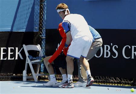 Daniel Gimeno-Traver (front) of Spain assists an official in helping a ball boy who collapsed during his men's singles match against Milos Raonic of Canada at the Australian Open 2014 tennis tournament in Melbourne January 14, 2014. REUTERS/Brandon Malone