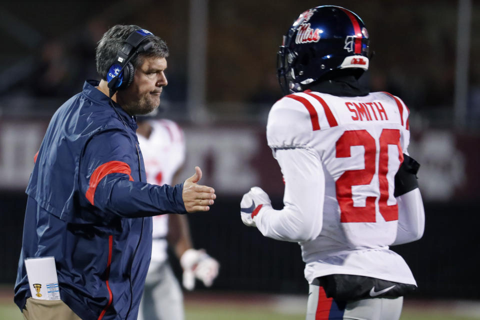 In this Nov. 28, 2019 photo, Mississippi head coach Matt Luke reaches out to Mississippi defensive back Keidron Smith (20) following a second half play during an NCAA college football game against Mississippi State, in Starkville, Miss. Mississippi has fired Luke, three days after his third non-winning season ended with an excruciating rivalry game loss. Athletic director Keith Carter said Sunday, Dec. 1, 2019 the decision to change coaches was made after evaluating the trajectory of the program and not seeing enough “momentum on the field. (AP Photo/Rogelio V. Solis)