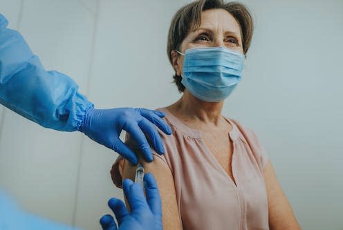 <span class="caption">Bivalent vaccines target omicron alongside the original strain of COVID.</span> <span class="attribution"><a class="link " href="https://www.shutterstock.com/image-photo/male-doctor-protective-overall-face-shield-1907416363" rel="nofollow noopener" target="_blank" data-ylk="slk:Lithiumphoto/Shutterstock;elm:context_link;itc:0;sec:content-canvas">Lithiumphoto/Shutterstock</a></span>