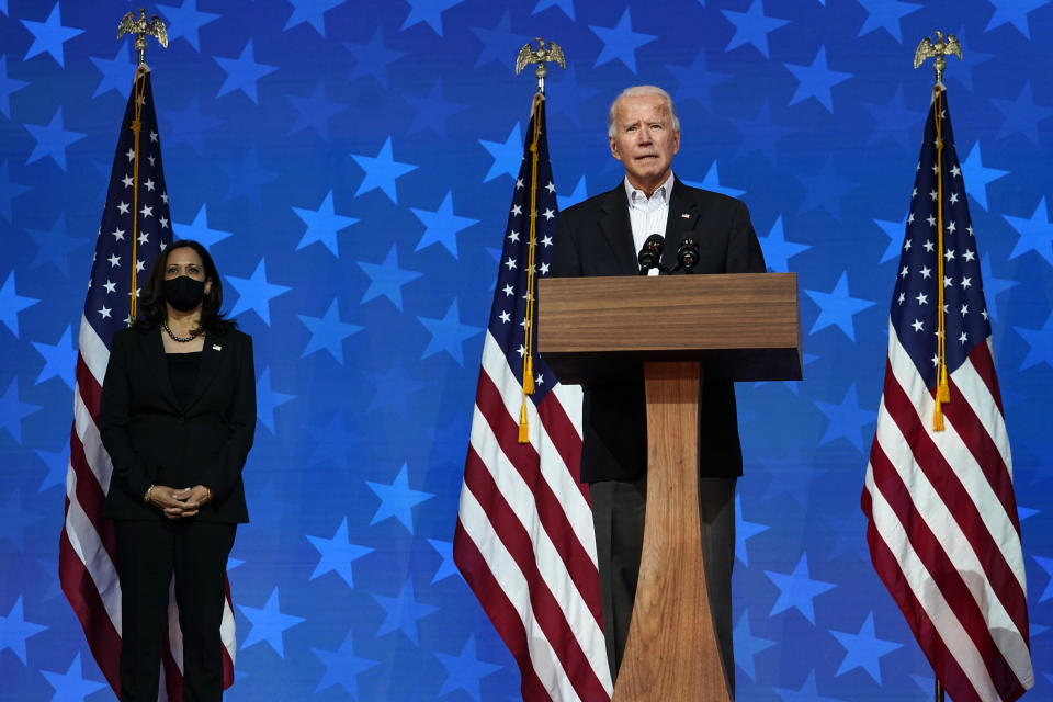 FILE - In this Nov. 5, 2020, Democratic presidential candidate former Vice President Joe Biden speaks in Wilmington, Del. Democratic vice presidential candidate Sen. Kamala Harris, D-Calif., stands at left. A tough road lies ahead for Biden who will need to chart a path forward to unite a bitterly divided nation and address America’s fraught history of racism that manifested this year through the convergence of three national crises. (AP Photo/Carolyn Kaster, File)