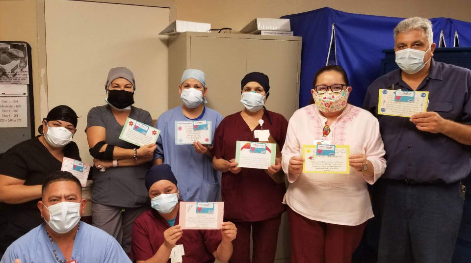 In this June 30, 2020, photo provided by Keith Levy, health care workers hold thank-you cards at Los Angeles Community Hospital in Los Angeles. Siblings Mantej Singh Lamba, 17, and Prabhleen Singh Lamba, 15, started the Cards 4 Covid Heroes initiative in May and have since delivered more than 250 cards to hospitals in California and Arizona. (Keith Levy via AP)