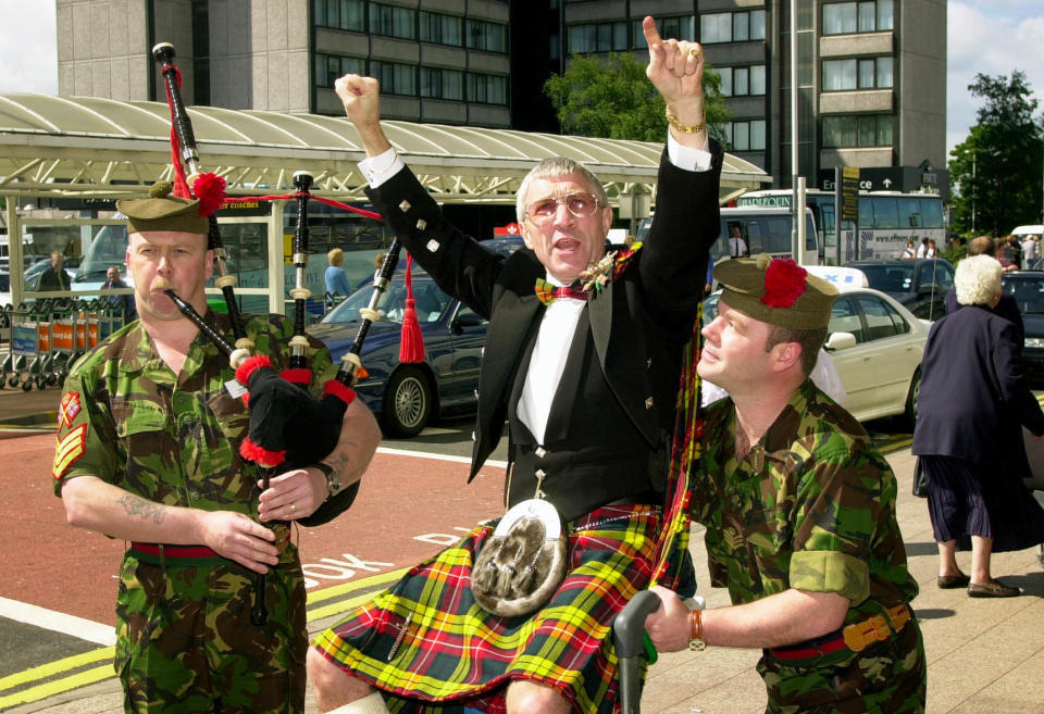 El boxeador escocés Ken Buchanan es canalizado por el sargento Dave Smith (L) y el sargento de color Ally Alcorn en el aeropuerto de Glasgow en su camino a los Estados Unidos, donde será inaugurado en el Salón de la Fama del Boxeo Americano y se convertirá en el único boxeador británico vivo en tener hecho.  (Foto de Ben Curtis - PA Images/PA Images vía Getty Images)