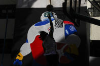 A man plays basketball in front of a wall painted with JIP, the FIBA Basketball World Cup mascot, Thursday, Aug. 17, 2023, in Taguig city Philippines. Basketball’s World Cup starts on Friday, Aug. 25, spread out over three nations. The Philippines, Japan and Indonesia all will be hosts. It’ll be centered in Manila. The home nation has declared Friday a national holiday of sorts, closing schools and some businesses to mark the occasion of the tournament opening. (AP Photo/Aaron Favila)