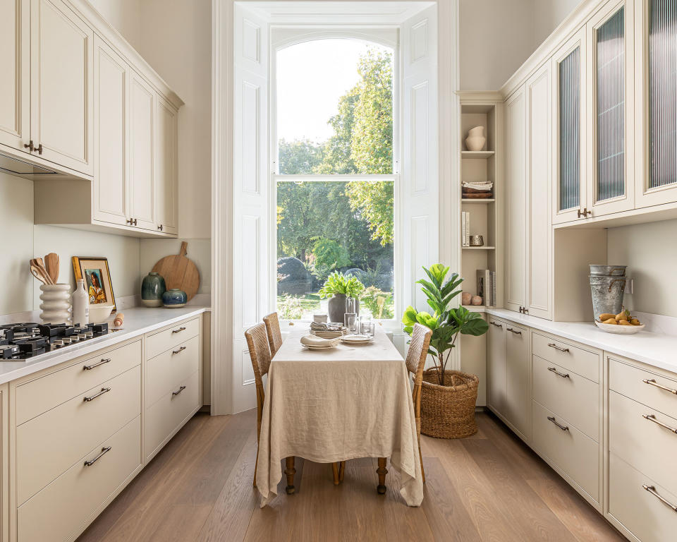 Beige kitchen with Shaker style cabinets and island table