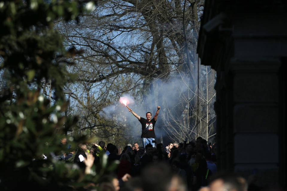 A man holds a burning torch during a protest in front of the Serbian presidency building in Belgrade, Serbia, Sunday, March 17, 2019. While Serbian president Aleksandar Vucic held a news conference in the presidency building in downtown Belgrade, some thousands of opposition supporters gathered in front demanding his resignation. (AP Photo/Darko Vojinovic)