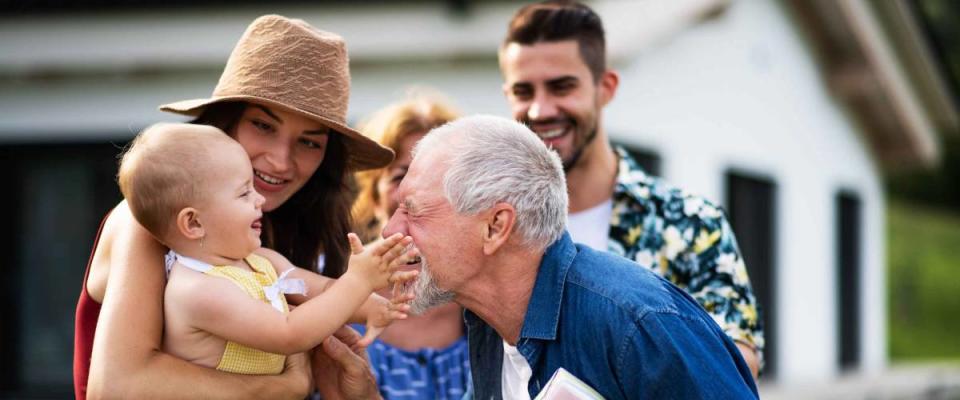 Portrait of multigenerational family outdoors on garden barbecue.