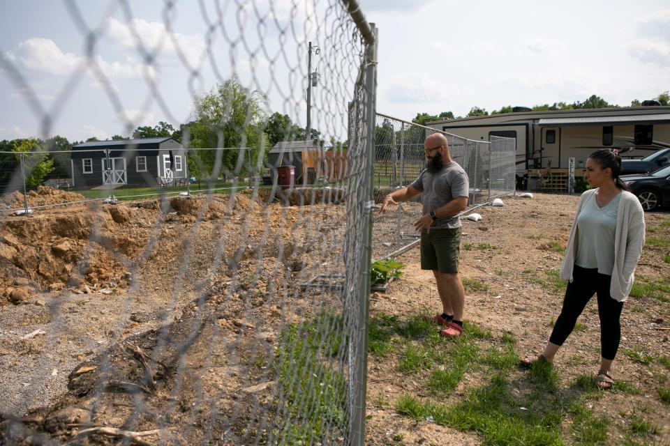 Vicky and Chad Burnett stand in front of the hole where their house use to be on May 23, 2023, in Huntington Township, Ohio. The Burnett's home burned down on March 5, 2023. Impressed with the response from the local fire departments, Chad is thinking of becoming a local firefighter. His application to the Huntington Township Fire Department has been approved.