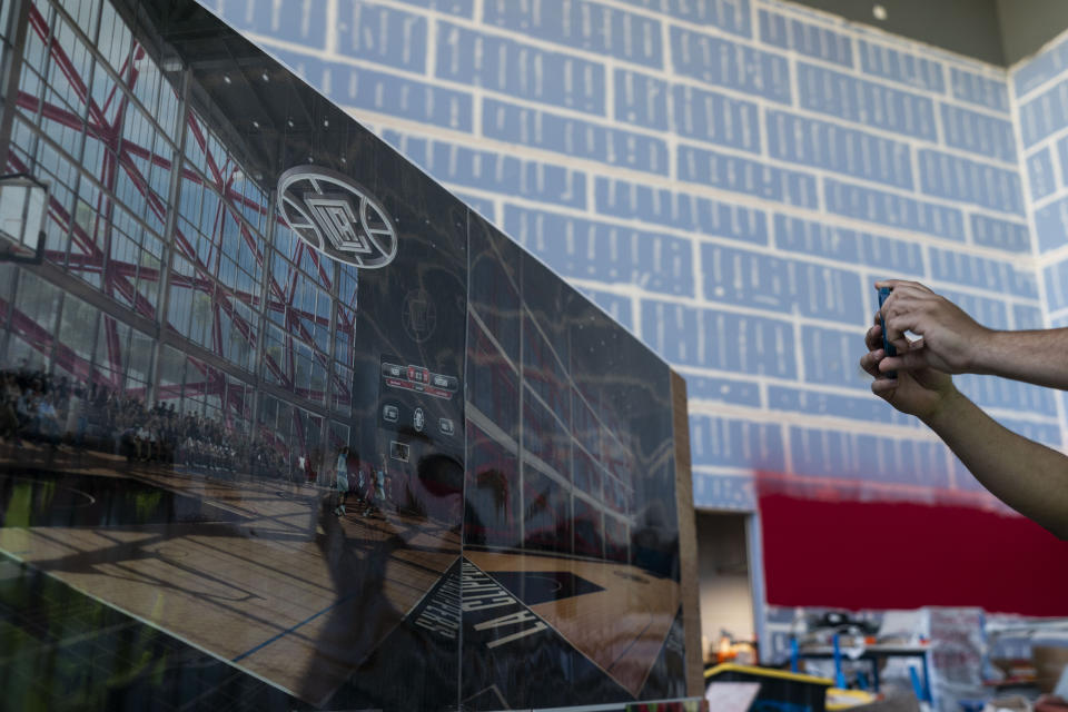 A reporter takes pictures of a rendering during a media tour of the Los Angeles Clippers' Intuit Dome in Inglewood, Calif., Thursday, June 22, 2023. The arena is expected to be completed in time for the 2024-25 NBA season. (AP Photo/Jae C. Hong)