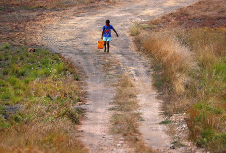 A boy carries a container filled with water as he walks towards his house in the village of Papa Lealea located on the outskirts of Port Moresby, Papua New Guinea, November 19, 2018. REUTERS/David Gray