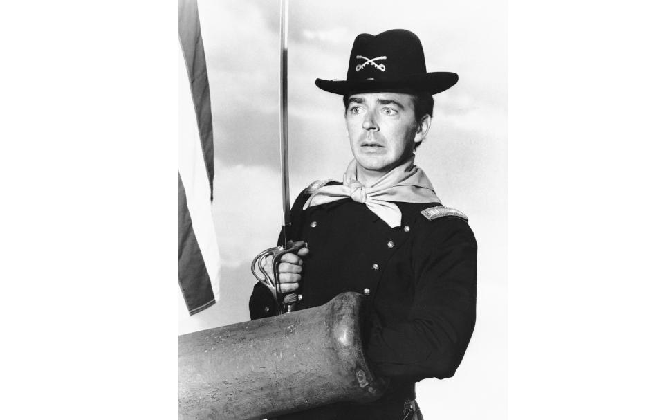 FILE - In a July 1, 1965 file photo, Ken Berry, who plays Captain Wilton Parmenter in a TV series called "F Troop," reaches down the wrong end of cannon in one of the show's episodes. A spokeswoman at Providence St. Joseph in Burbank, Calif., confirmed Berry died Saturday, Dec. 1, 2018. He was 85. (AP Photo, File)