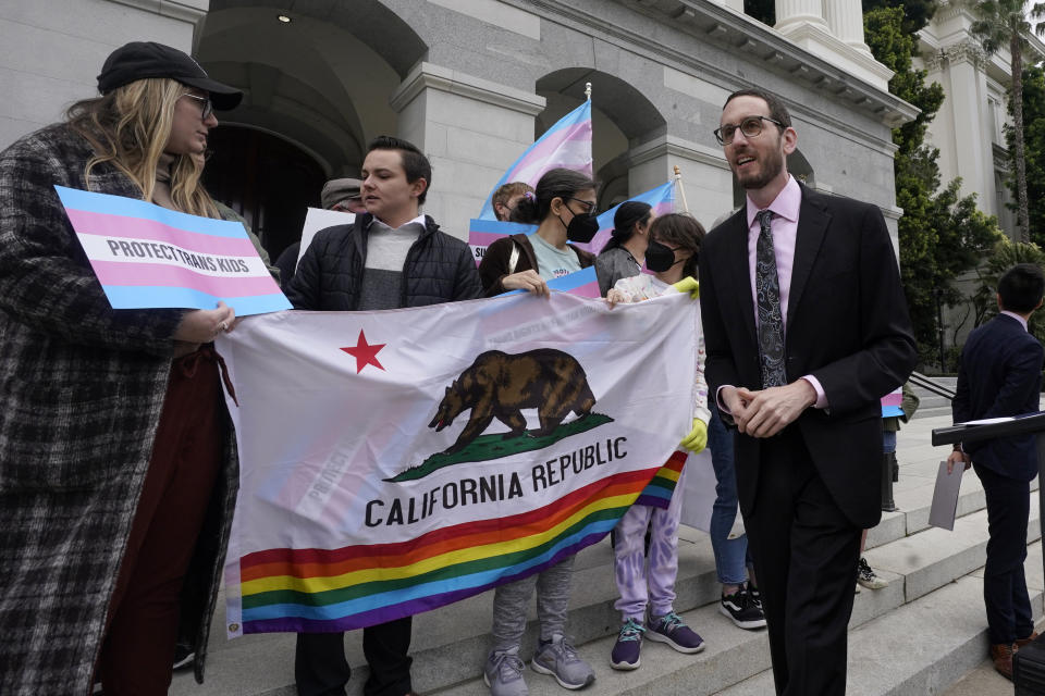 FILE - State Sen. Scott Wiener, D-San Francisco, right, prepares to announce his proposed measure to provide legal refuge to displaced transgender youth and their families during a news conference in Sacramento, Calif., Thursday, March 17, 2022. After the Nov. 8 election several newly elected lawmakers will join Wiener and other members of the LGBTQ caucus which will now make up 10% of the California state Legislature. (AP Photo/Rich Pedroncelli, File)