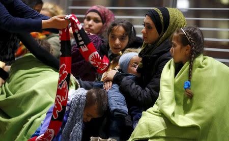 Wellwishers offer warm clothing to Syrians after they arrived on a train from Budapest's Keleti station at the railway station of the airport in Frankfurt, Germany, early morning September 6, 2015. REUTERS/Kai Pfaffenbach