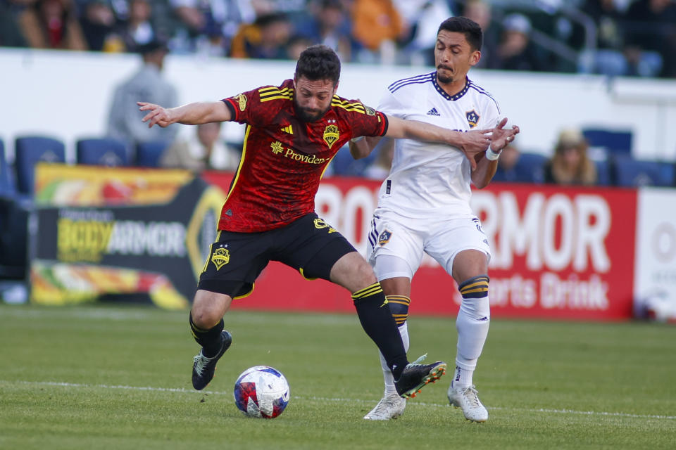 Seattle Sounders midfielder Joao Paulo Mior, left, and LA Galaxy midfielder Mark Delgado vie for the ball during the second half of an MLS soccer match in Carson, Calif., Saturday, April1, 2023. (AP Photo/Ringo H.W. Chiu)