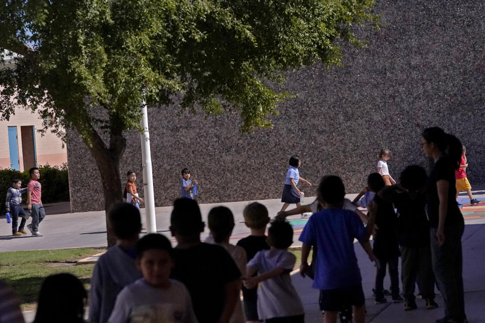 Whittier Elementary School students change classes, Tuesday, Oct. 18, 2022 in Mesa, Ariz. Like many school districts across the country, Mesa has a teacher shortage due in part due to low morale and declining interest in the profession. Five years ago, Mesa allowed Whittier to participate in a program making it easier for the district to fill staffing gaps, grant educators greater agency over their work and make teaching a more attractive career. The model, known as team teaching, allows teachers to combine classes and grades rotating between big group instruction, one-on-one interventions, small study groups or whatever the team agrees is a priority each day. (AP Photo/Matt York)