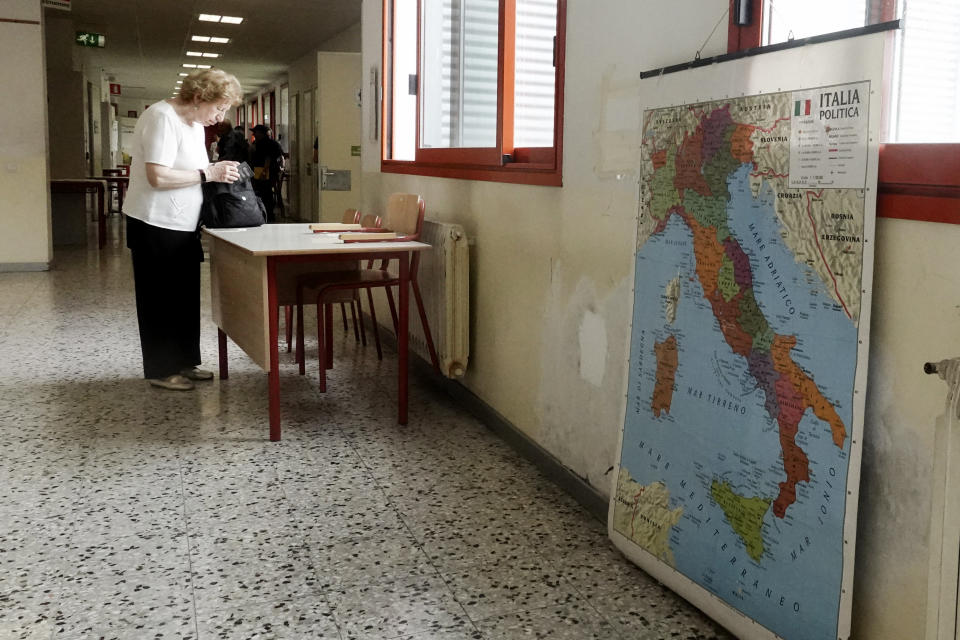 An elderly woman checks her voting paper before entering a polling station in Milan, Italy, Sunday, June 9, 2024. Tens of millions across the European Union were voting in EU parliamentary elections on Sunday in a massive exercise of democracy that is expected to shift the bloc to the right and redirect its future. (AP Photo/Luca Bruno)