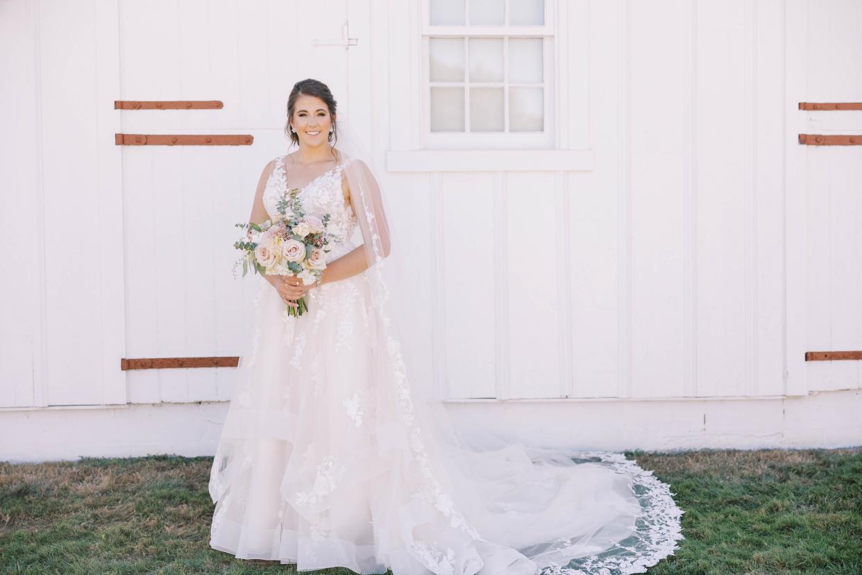 Bride wearing wedding dress designed by Samantha Nietz holding bouquet